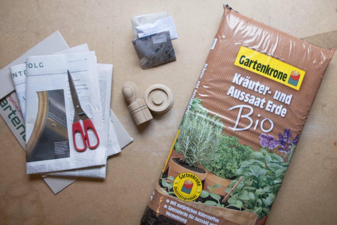 Material, um Pflanzen vorzuziehen: Gartenerde, Saatgut, Papier und ein Paperpotter.