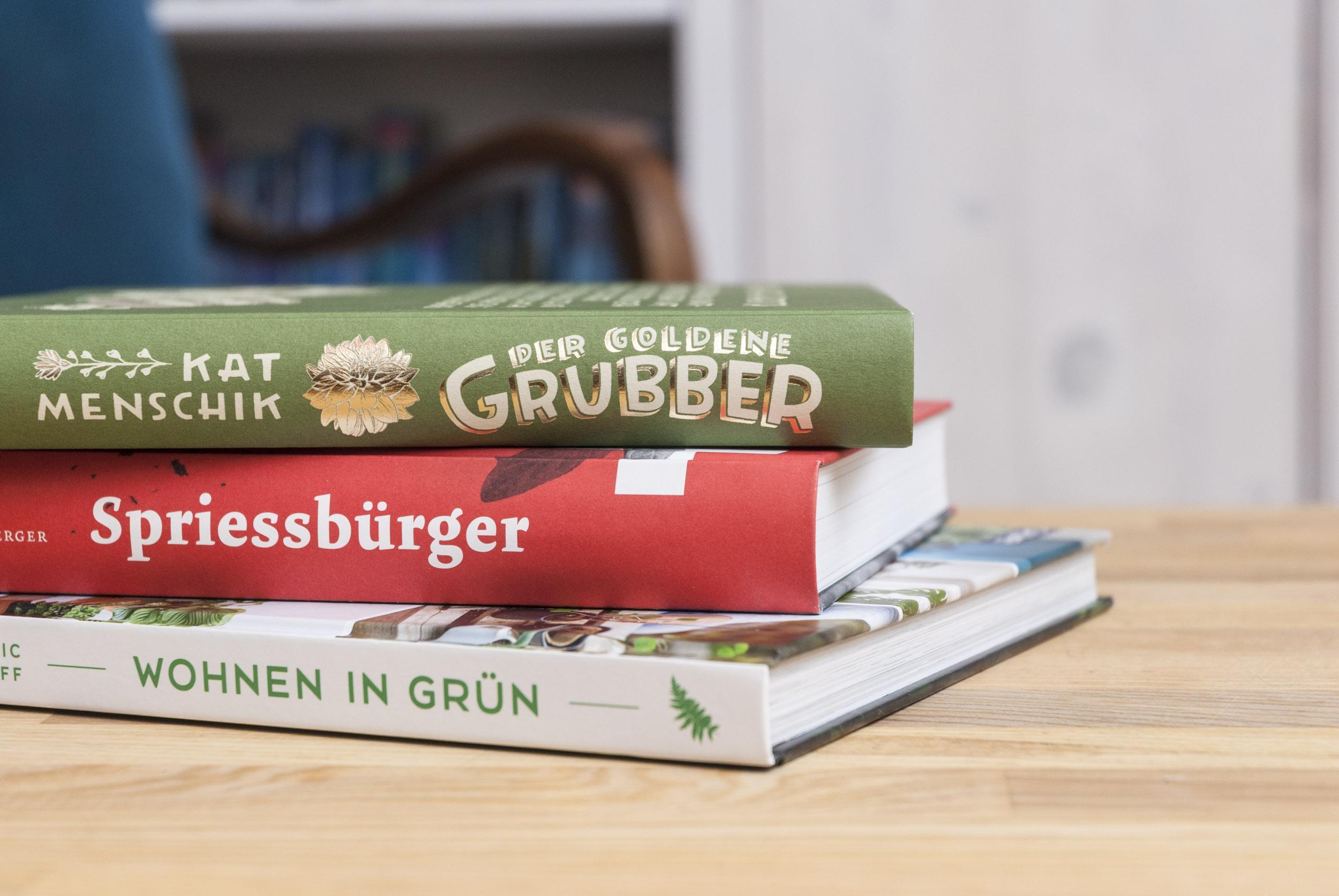 Der goldene Grubber, Spriessbürger, Wohnen in Grün: Drei Bücher liegen aufeinander gestapelt auf einem Tisch.