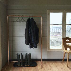 Eine DIY-Kleiderstange steht in einem Raum einer Gartenhütte.