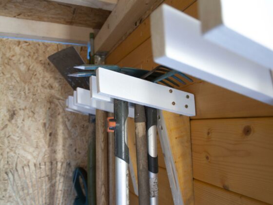 Gartengerätehalter selber bauen – Halterungen sin din einer Gartenlaube aus Holz an der Wand montiert.