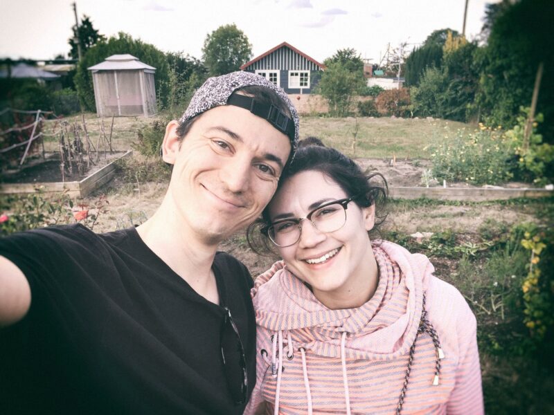 Kleingärtner werden: Selfie von zwei Menschen, die in einem Schrebergarten stehen.