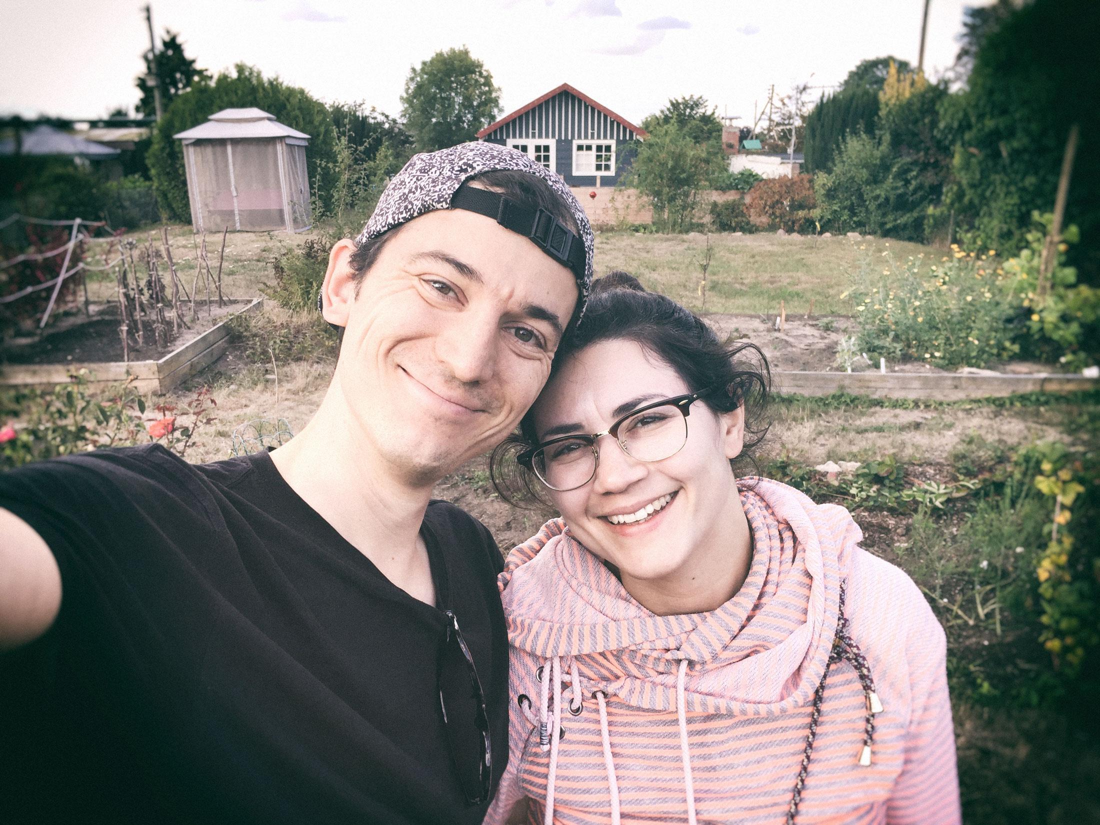 Kleingärtner werden: Selfie von zwei Menschen, die in einem Schrebergarten stehen.