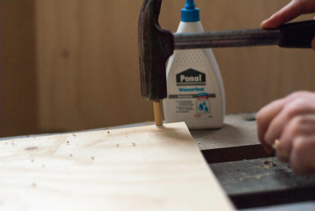 DIY-Küchenzeile: In eine Seitenwand wird ein mit Leim bestrichener Holzdübel eingesetzt. 