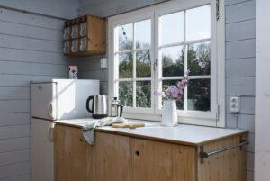 Eine fertige DIY-Küchenzeile in einer lichtgrau gestrichenen Gartenhütte.