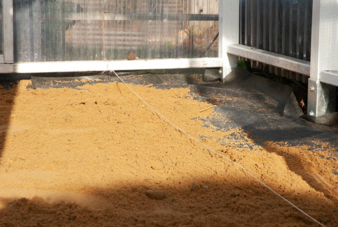 Gewächshaus selber bauen: der Boden wird mit Sand angeglichen und mit einem Unkrautvlies geschützt.