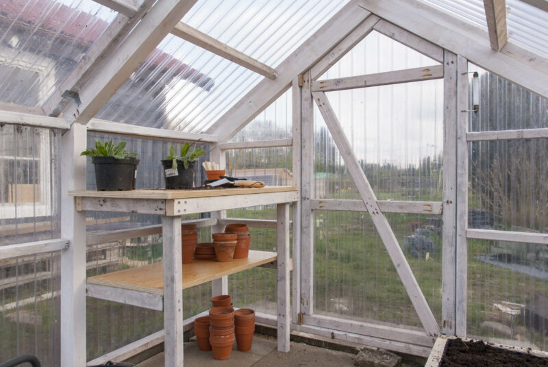 Pflanztisch selbst bauen: Ansicht eines eingerichteten Pflanztisches in einem Gewächshaus.