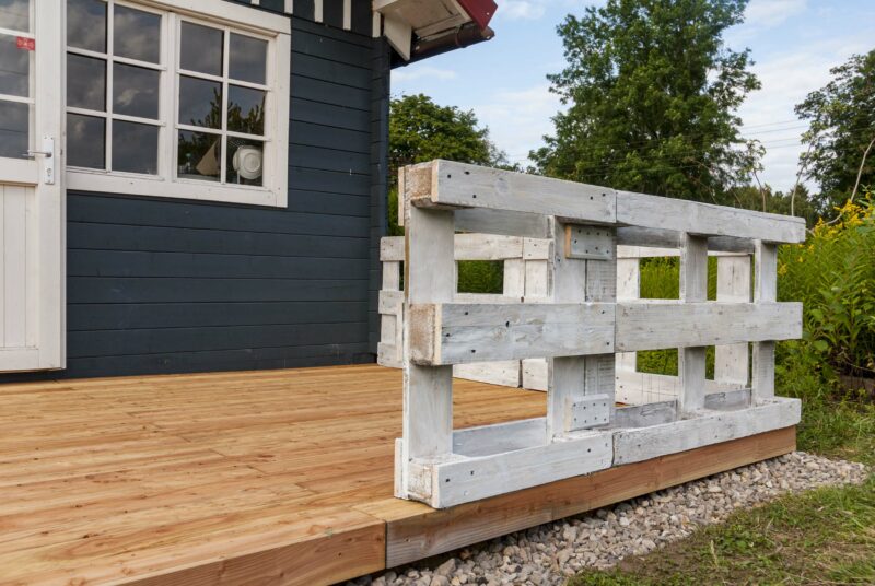 eine Gartenlaube mit einer selbst geabuten Holzterrasse davor