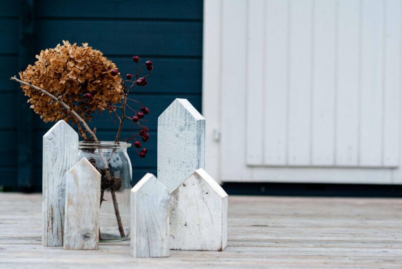 Dekohäuser aus Holz vor einer Gartenhütte.