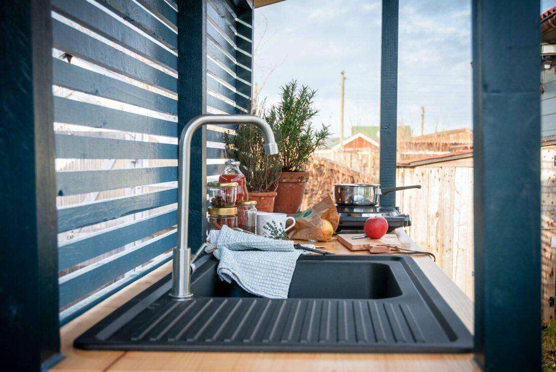 Ansicht eines Spülbeckens in einer selbst gebauten Außenküche. 