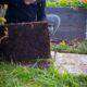 No Dig Gardening: Eine Frau schaut unter eine Holzplatte.