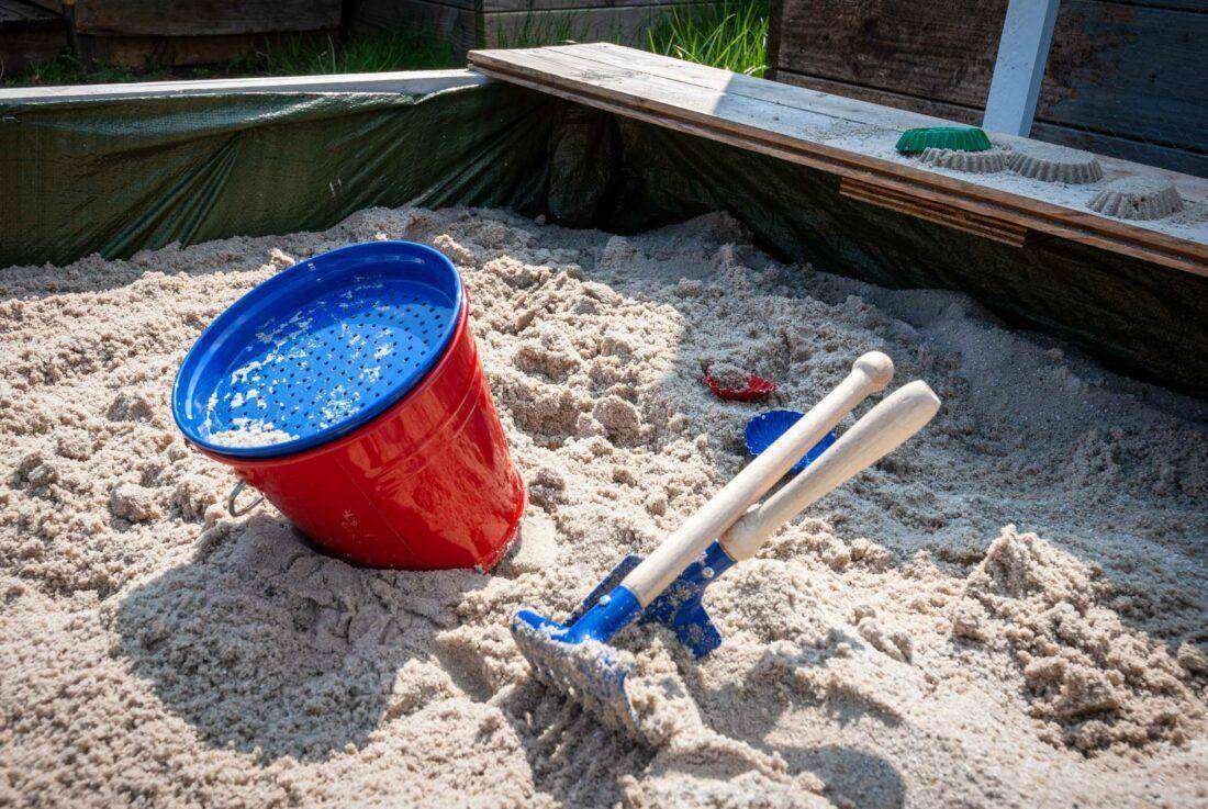 Sandkasten selber bauen: ein fertiger Sandkasten mit Sandspielzeug.