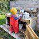 Ein Kind spielt in einer selbst gebauten Matschküche.