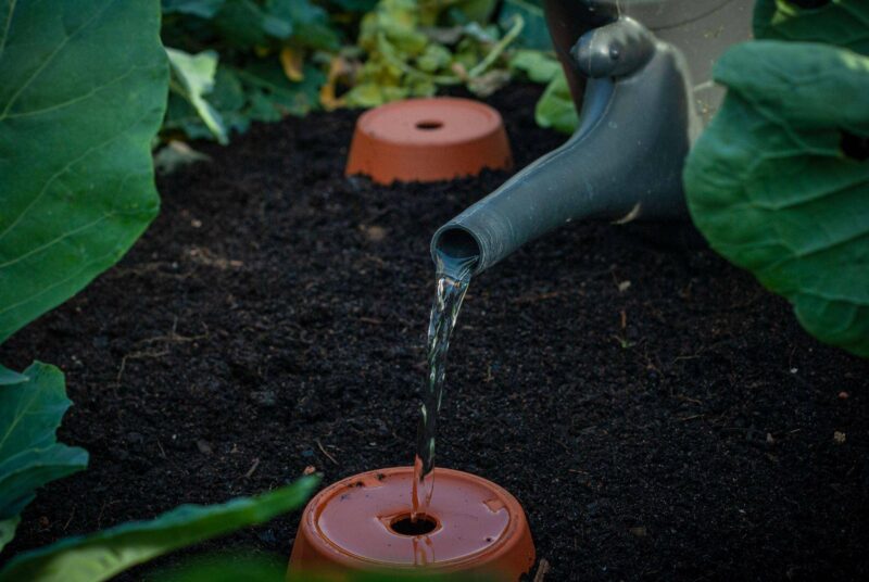 Ollas in einem Hochbeet werden befüllt