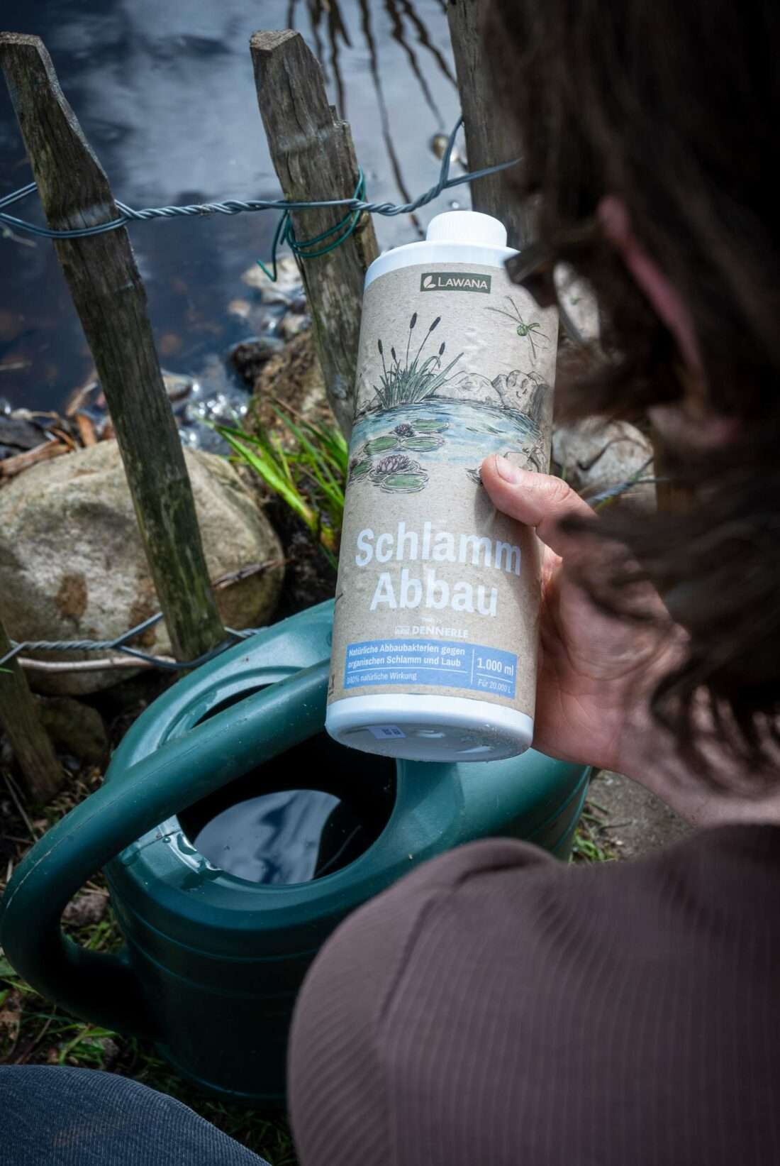 Eine Frau betrachtet einen Flasche Schlamm Abbau der Firma Lawana.