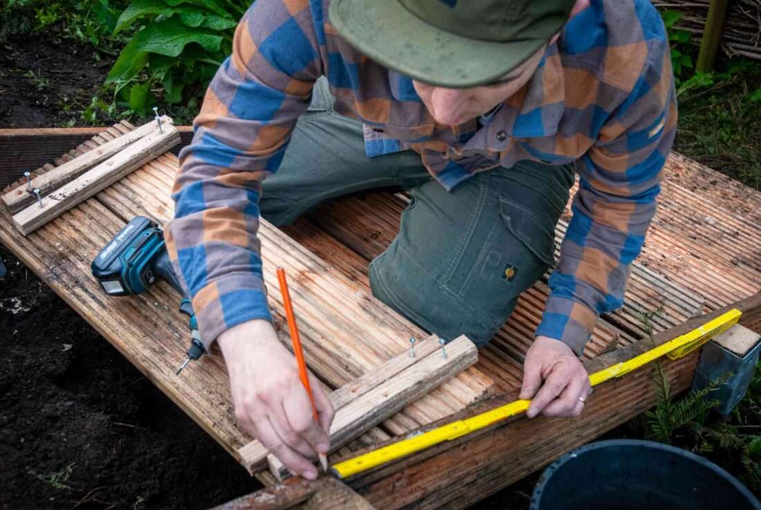 Holztreppe selber bauen: Ein Mann misst die Abstände bei Stufen aus.