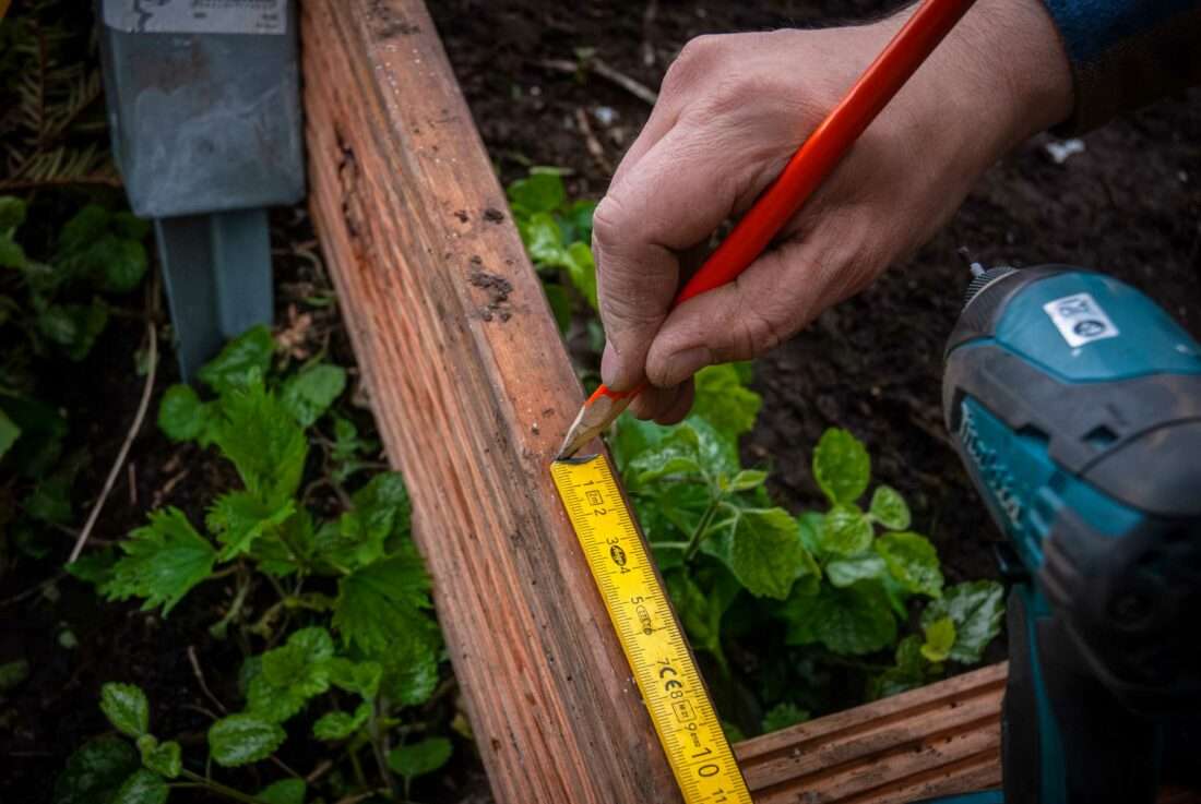 Ein Mann misst den Platz für eine weitere Stufe aus.
