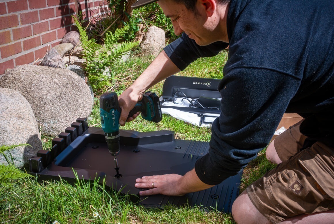 Blogger Florian Hucht befestigt die Docking-Station eines Mähroboters