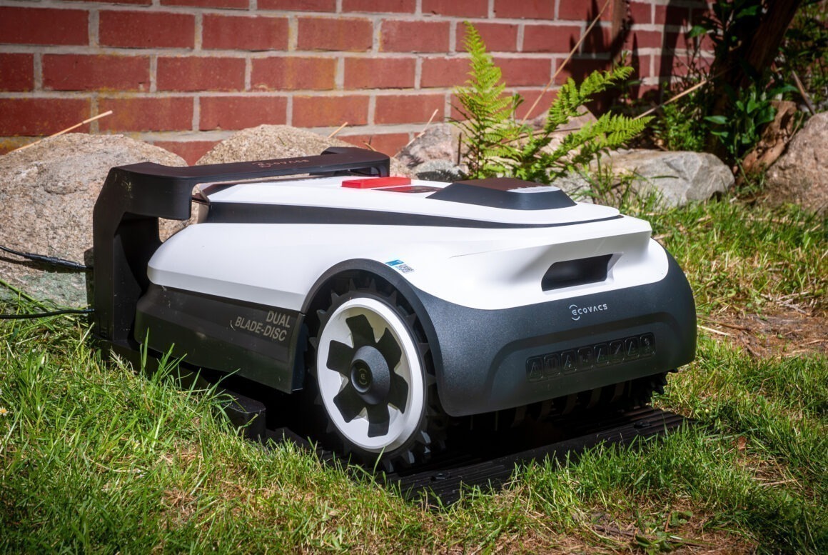 Ein ECOVAS Mähroboter steht in der Docking-Station. 