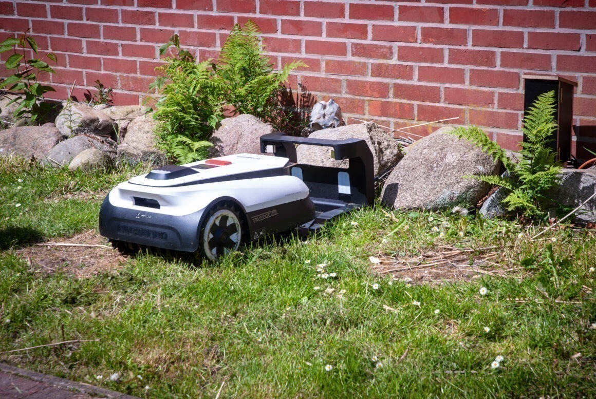 Ein Mähroboter von ECOVACS fährt in seine Docking-Station