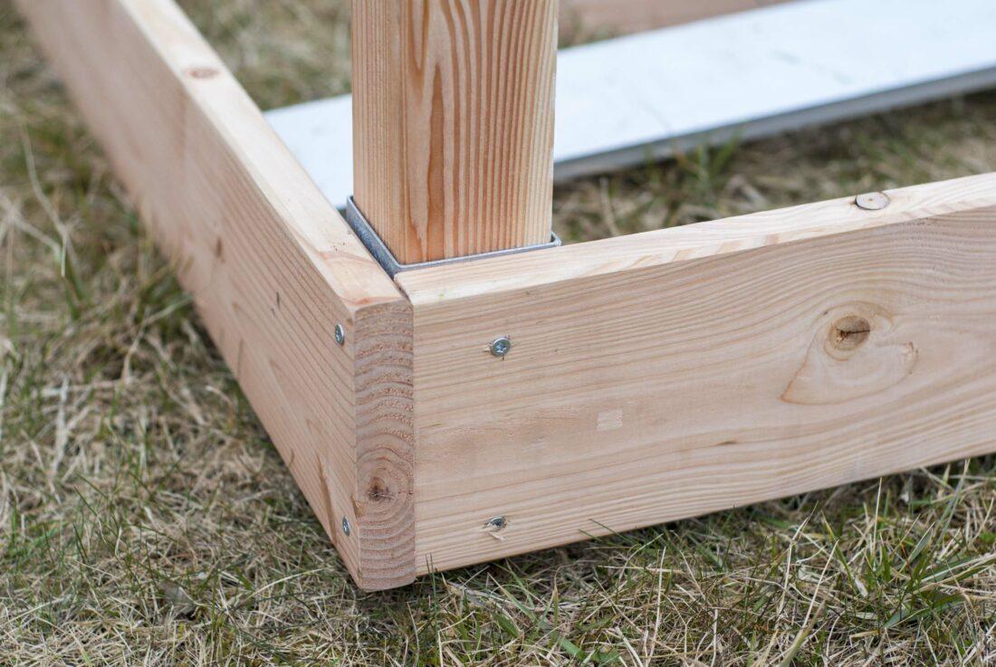Nahaufnahme einer Ecke eines selbst gebauten Hochbeets. 
