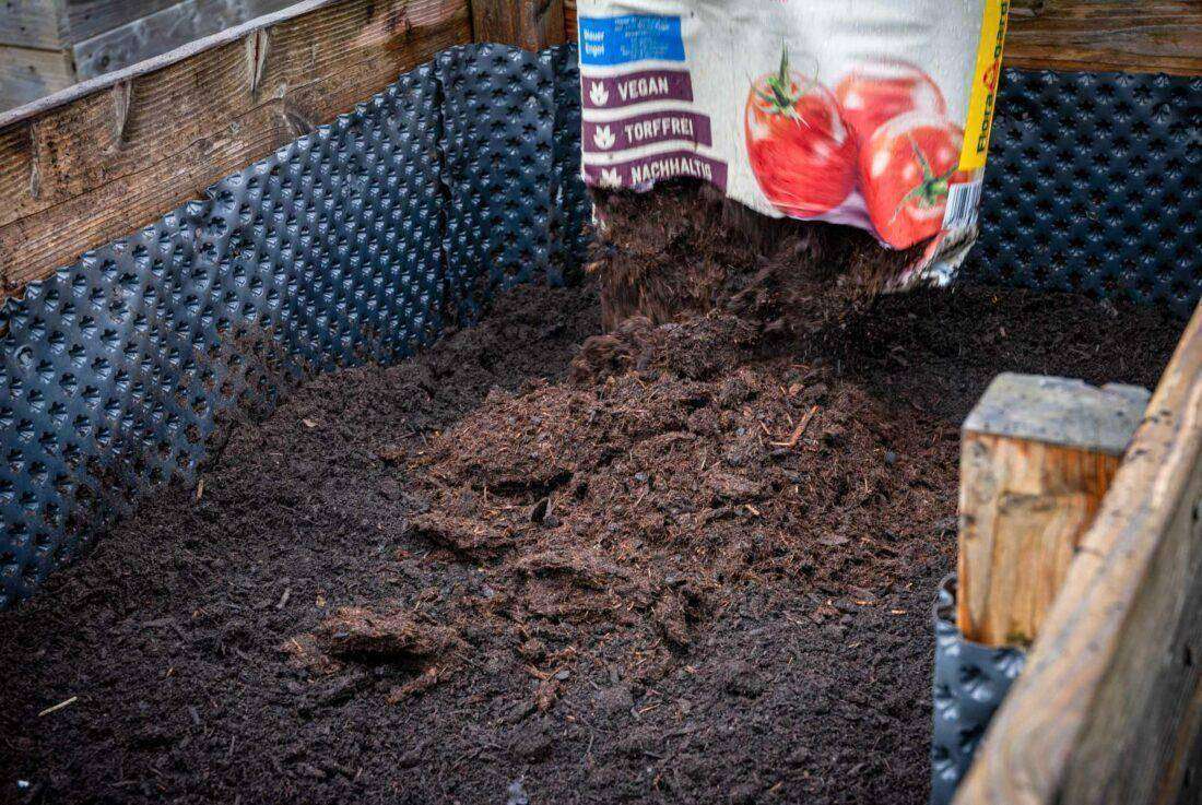 Ein Hochbeet wird mit Erde der Firma Floragard befüllt. 