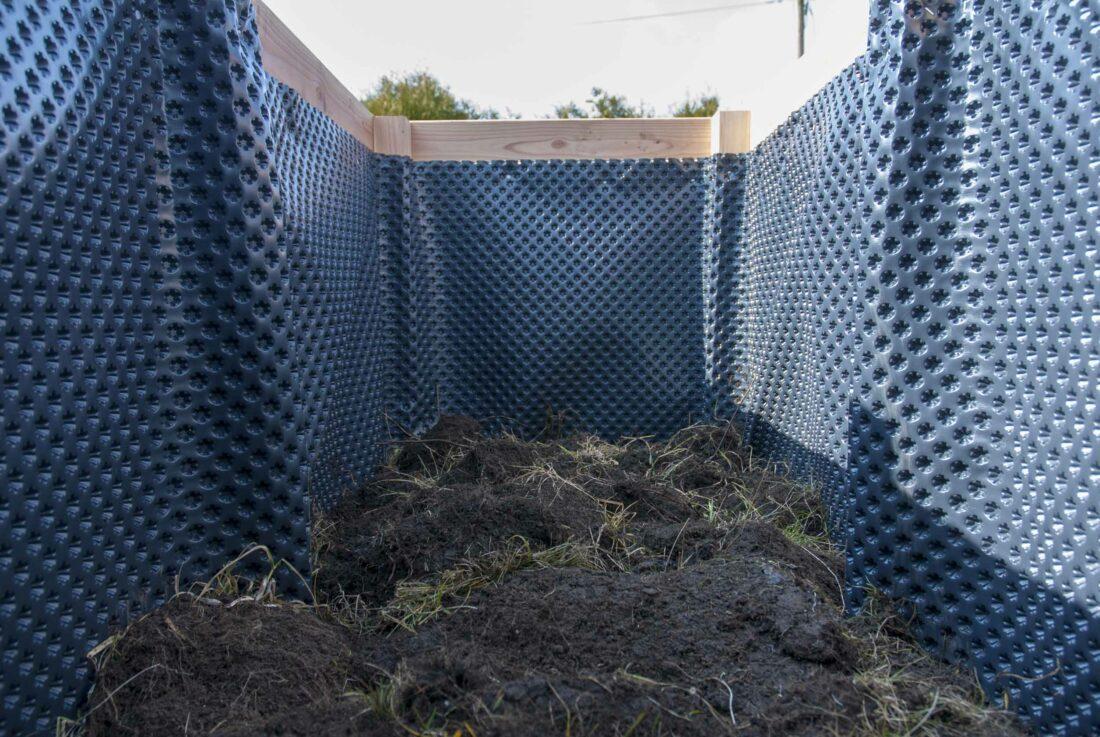 Hochbeet befüllen, Schicht 2: Nahaufnahme von Grassoden, die in einem Hochbeet aufgeschichtet wurden.