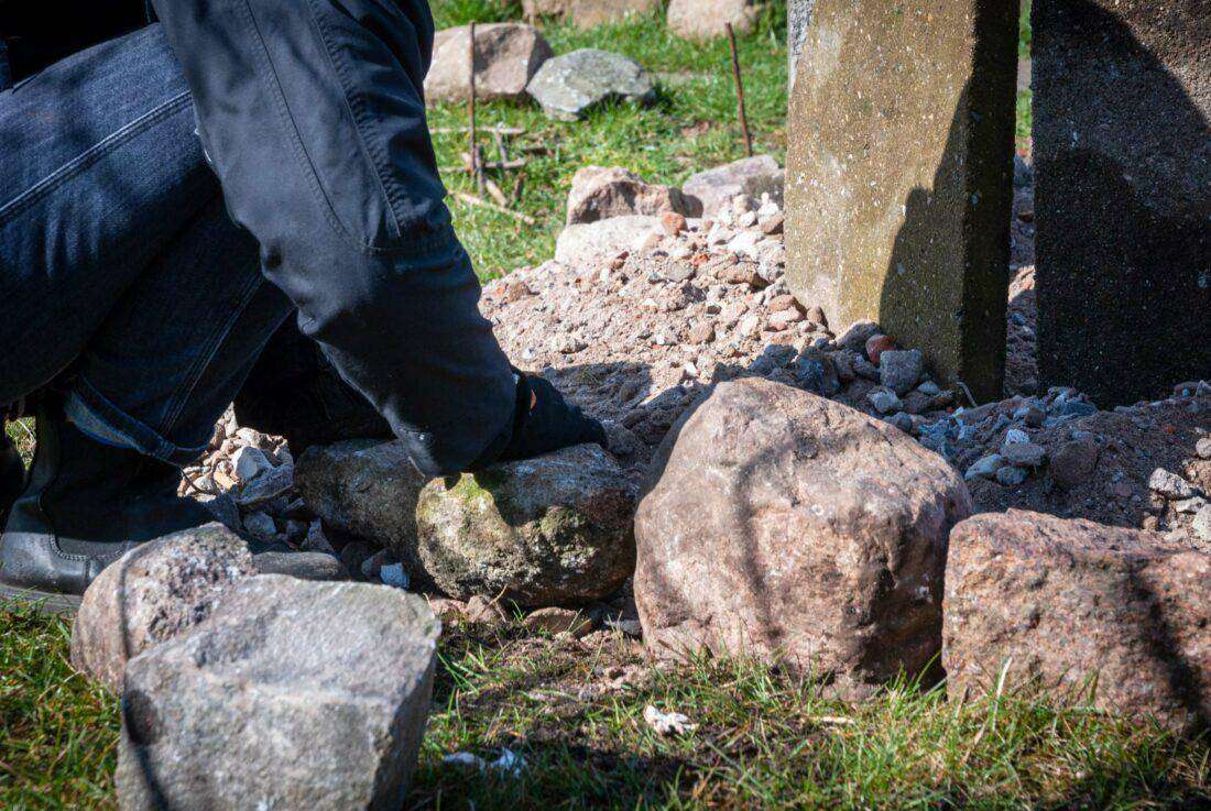 Eine Frau legt das Fundament für eine Kräuterspirale. 