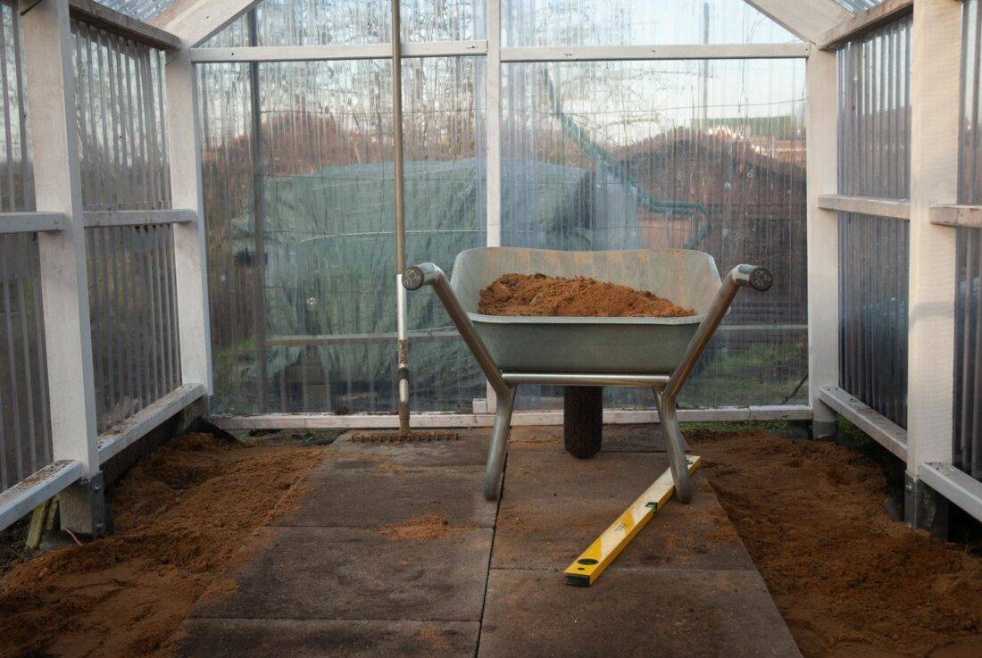 Ansicht eines halb fertiggestellten Steinplattenbodens in einem Gewächshaus.